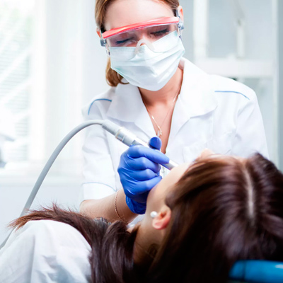 Фотография стоматолога в маске и очках за работой